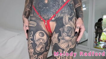 Melody Radford’s tiny bathing suit try-on haul in black and red zipper bikinis.